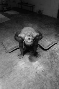 a black and white photo of a woman laying on a mat